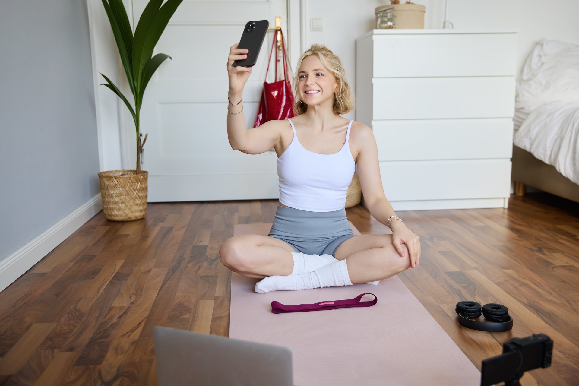 Aluna treinando em casa com faixa elástica, assinatura de treino para dança